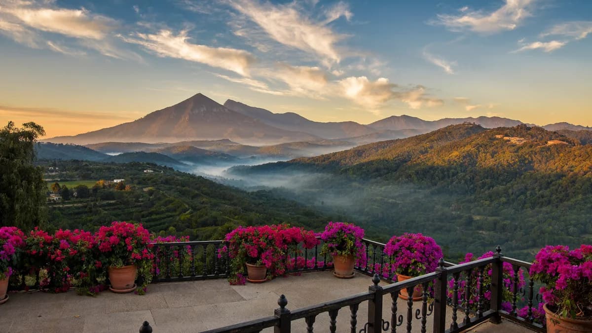 Cobblestone colonial street with blooming bougainvillea and panoramic view of the Colombian Andean mountain range