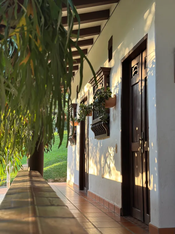 Pool terrace at a luxury finca in Antioquia with views over a green valley and the rocky peak, loungers and blue water